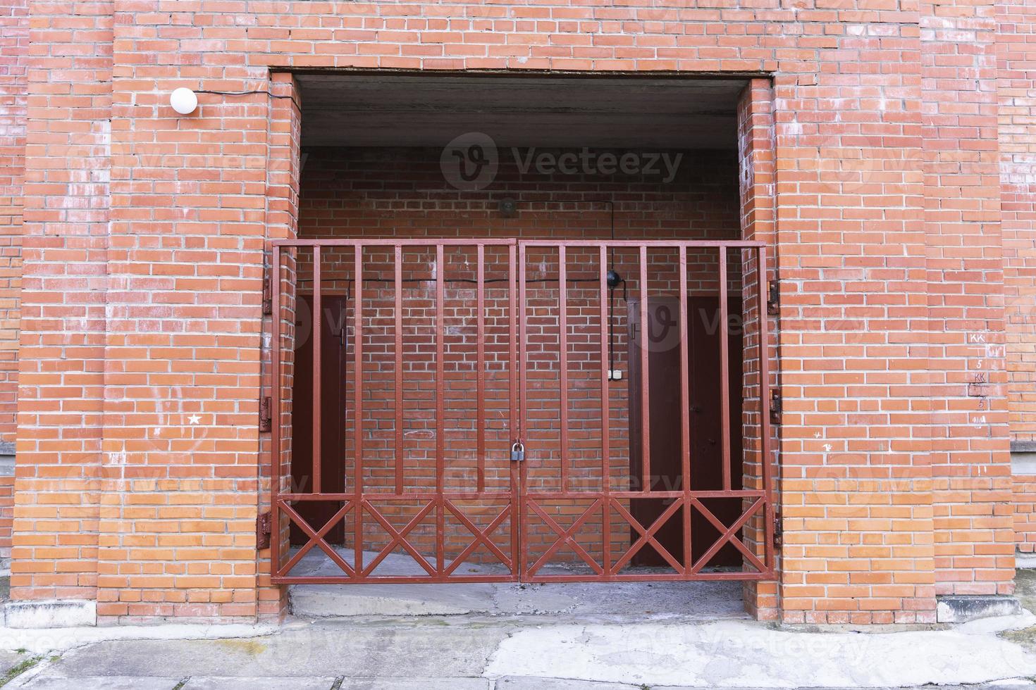 hierro enrejado puertas en el arco de un moderno ladrillo residencial edificio foto