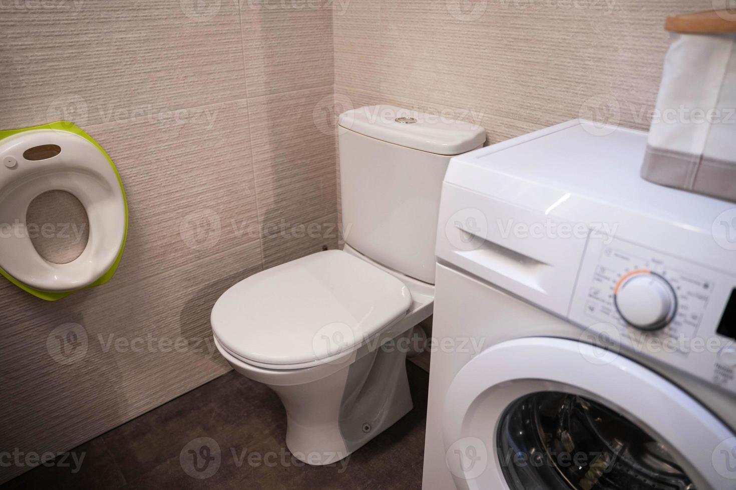 The furniture of the home toilet, toilet and washing machine, a seat for the little ones. photo