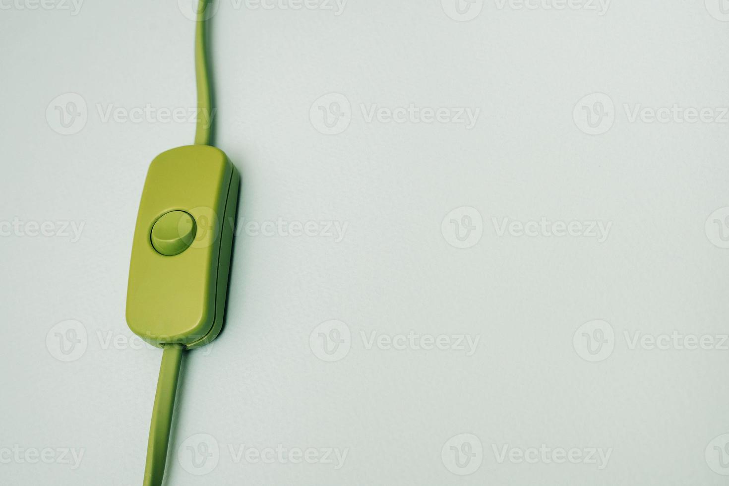 green electric wire with switch on turquoise background photo