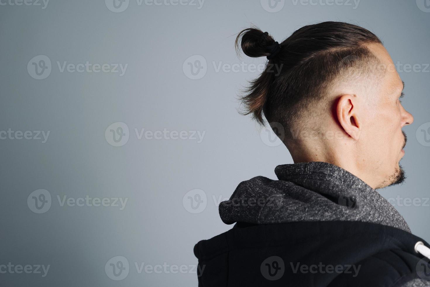 A close-up photo of a young man in a vest on the side