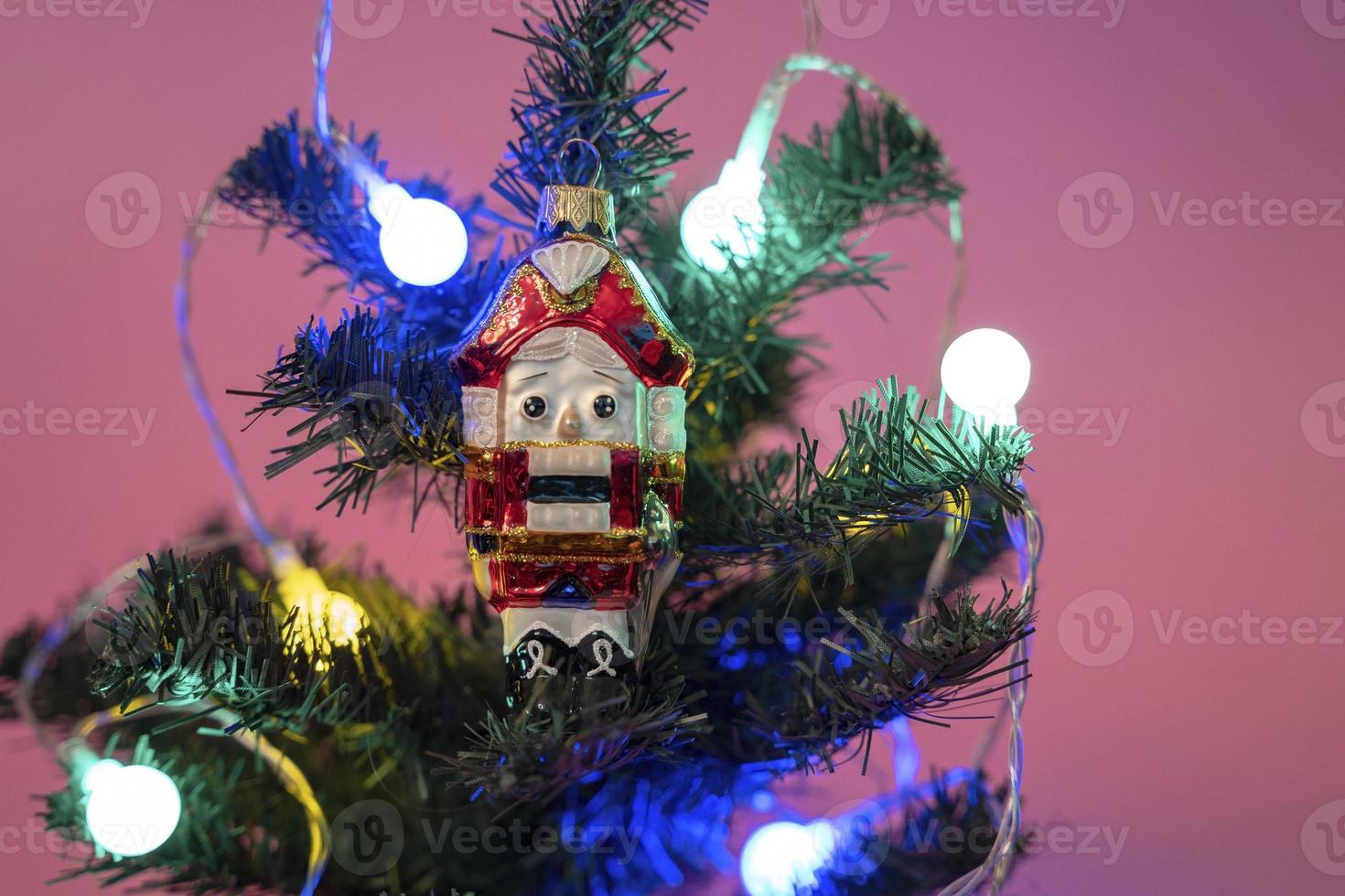 Christmas tree toy Nutcracker on a branch of a Christmas tree photo