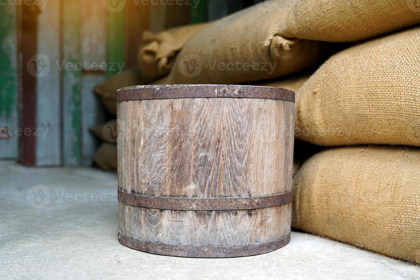 Thai Wooden bucket are used for measuring. Placed on a sack of rice. The bucket unit is a unit of measurement in Thailand in ancient times, with 1 bucket equal to 20 kilograms. photo