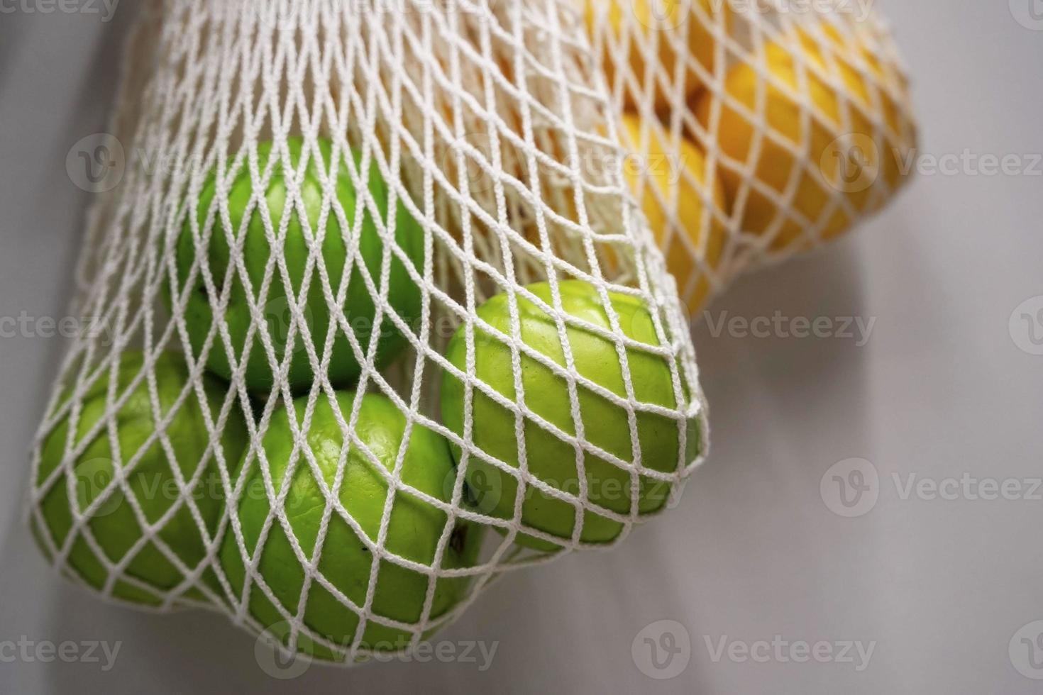 string bags with oranges and green apples, the concept of waste-free production photo