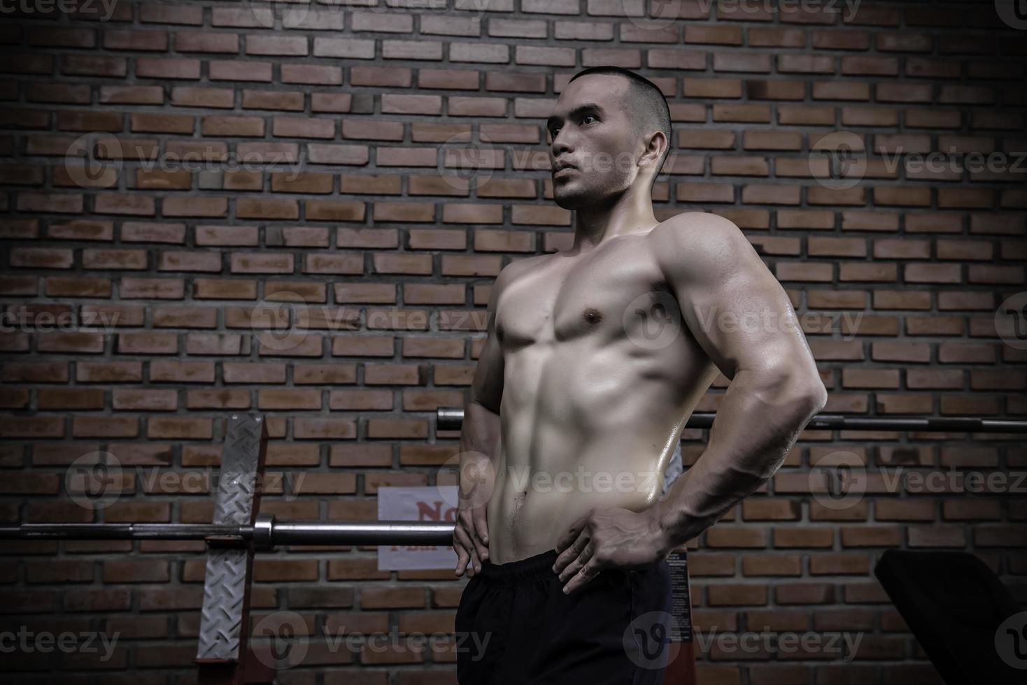 retrato de asiático hombre grande músculo a el gimnasio,tailandia gente,entrenamiento para bueno cuerpo saludable peso entrenamiento, fitness a el gimnasio concepto, broma a abdominal músculos foto