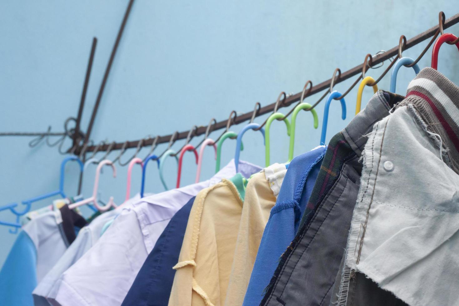 Clean clothes hanging dry in the sun side the concrete wall. photo