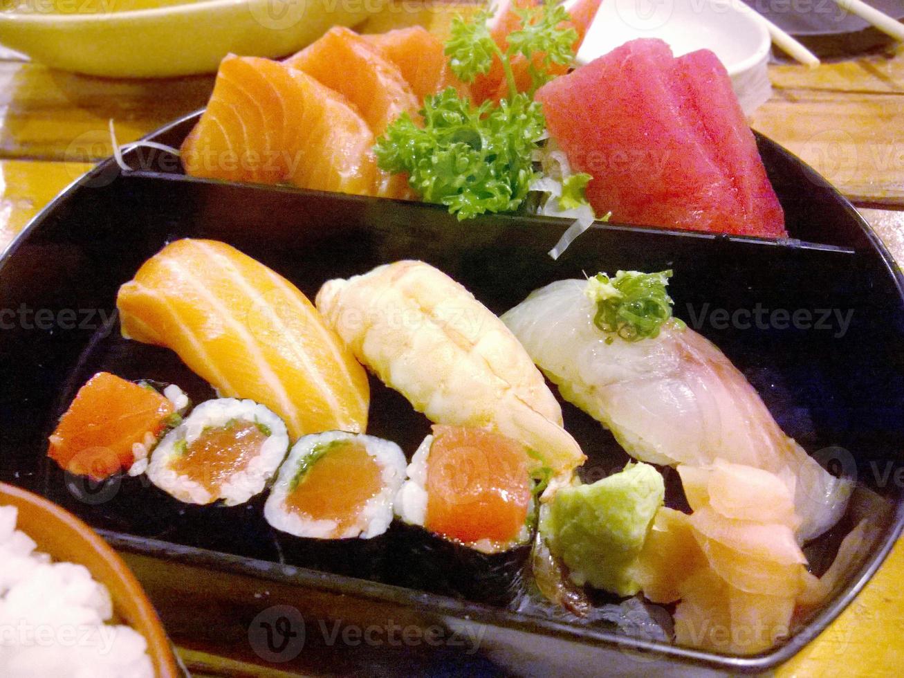 Closeup and crop Japanese food Sushi and Sashimi set on black blow and wooden table photo