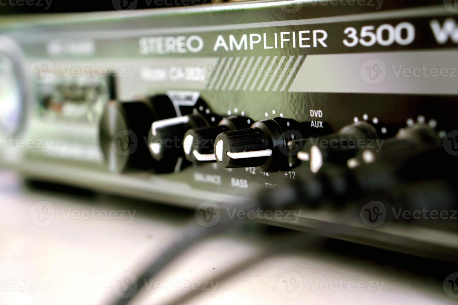 Closeup Volume and bass button in front of black stereo Amplifier. photo