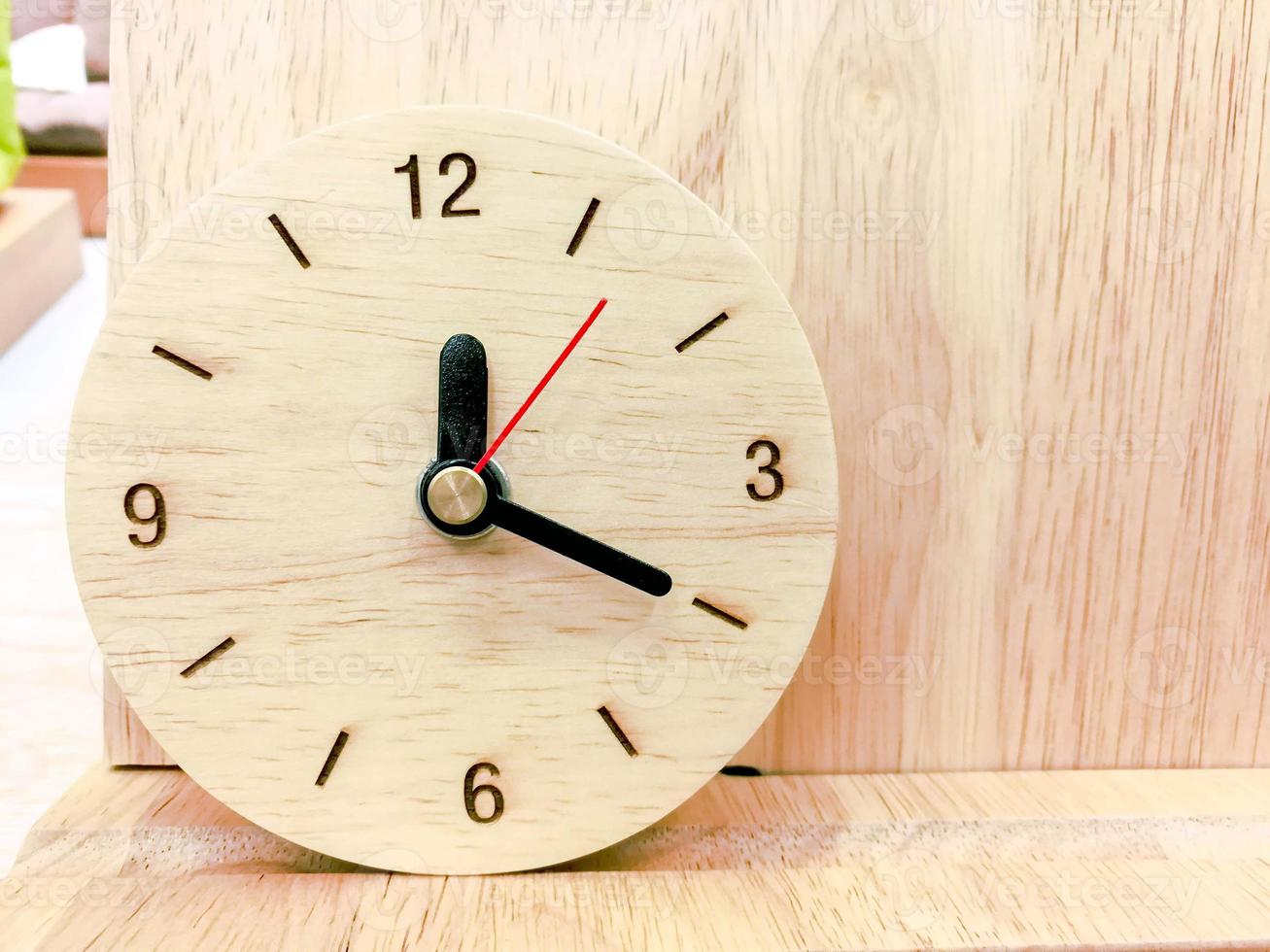 Closeup Wooden wall clock on wood background photo