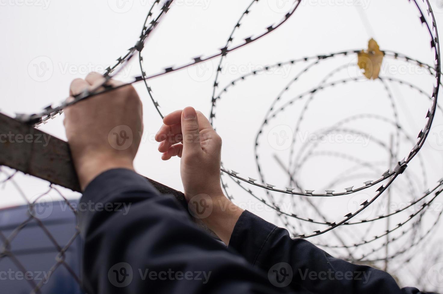 Men's hands on the background of barbed wire photo