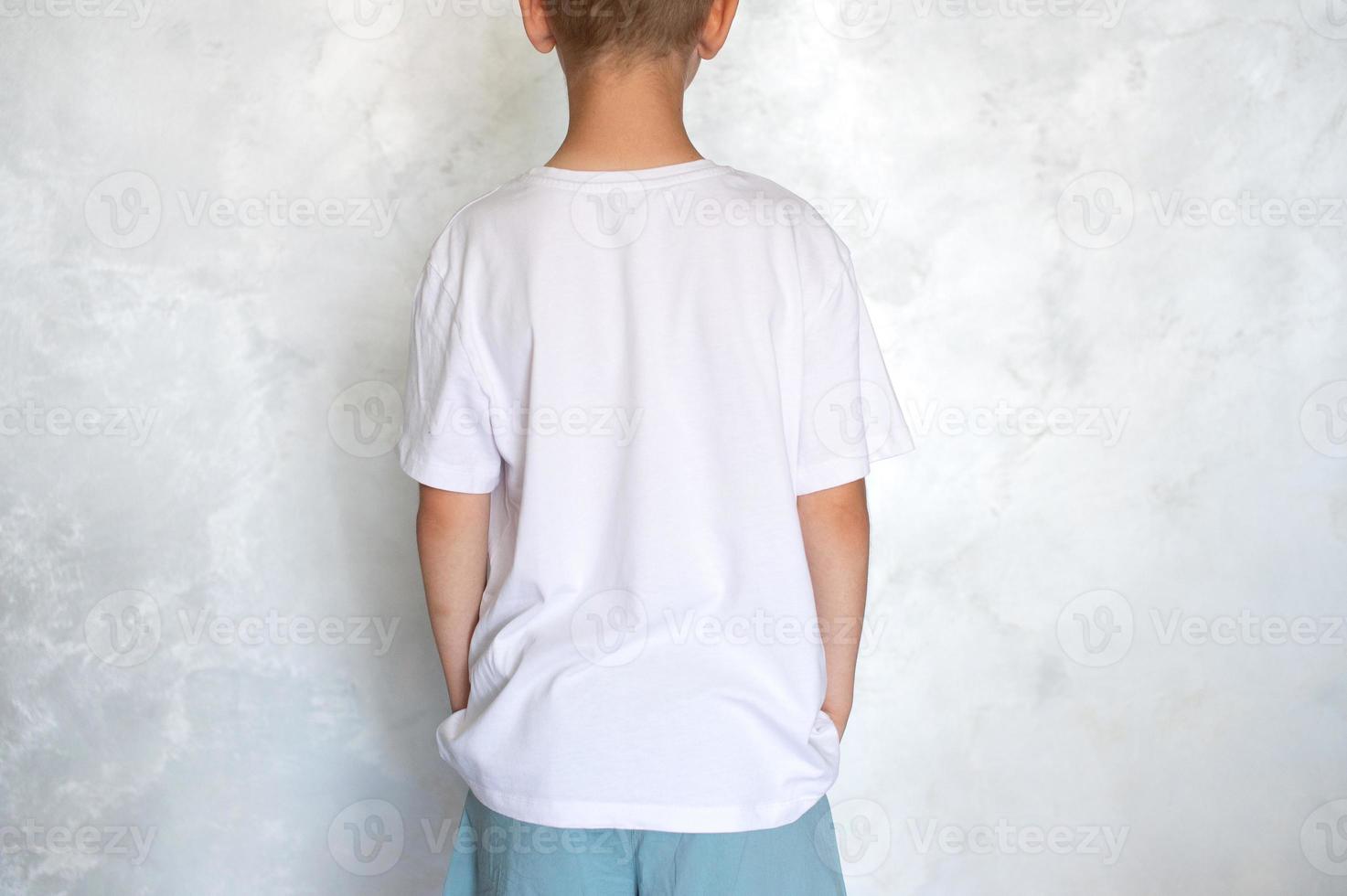 el niño es vistiendo un blanco camiseta. sitio para publicidad foto