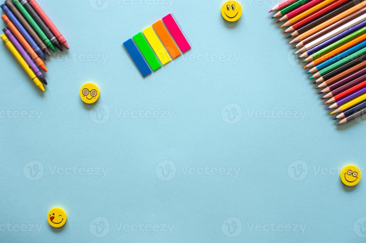 A set of bright stationery on a blue background. colored pencils and stickers photo