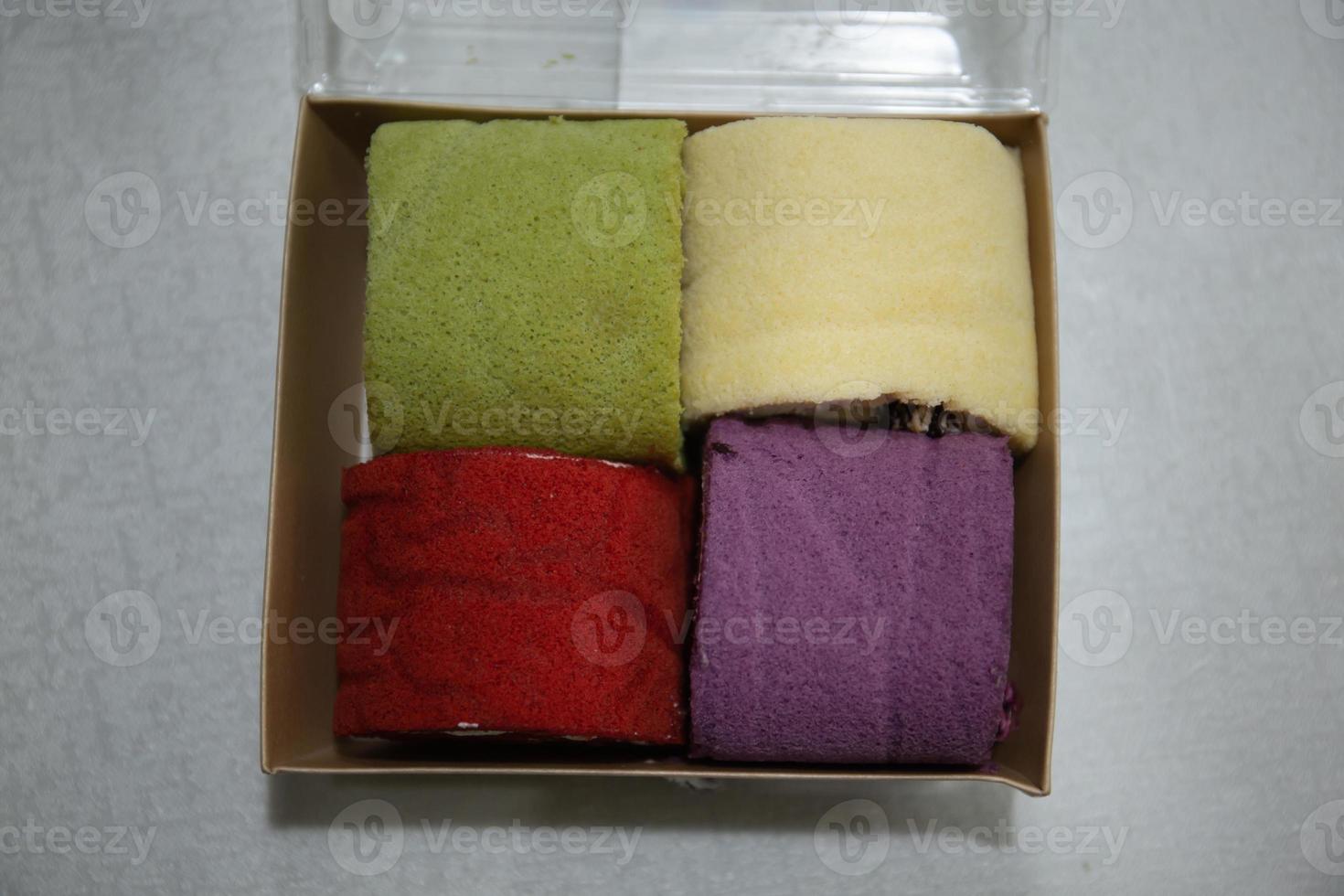 Photo of colourful mini roll cakes in a box