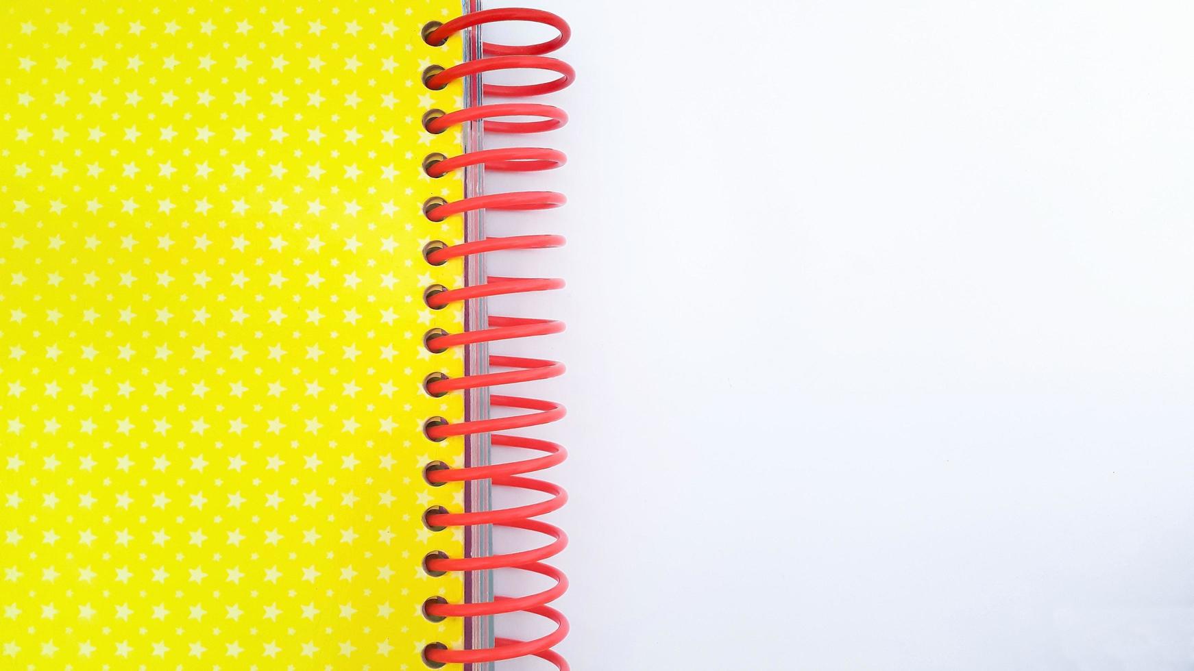 Close-up of red spiral bound notebook on white background photo