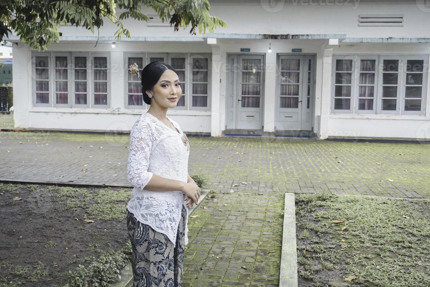 A young Indonesian woman with a happy successful expression wearing a white kebaya. Kartini's Day Concept. photo