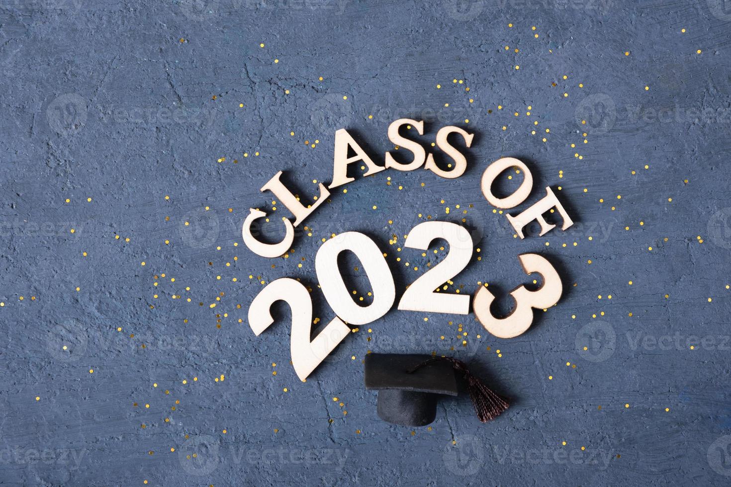 Class of 2023 banner concept. Wooden number 2023 with graduated cap on podium on dark background photo