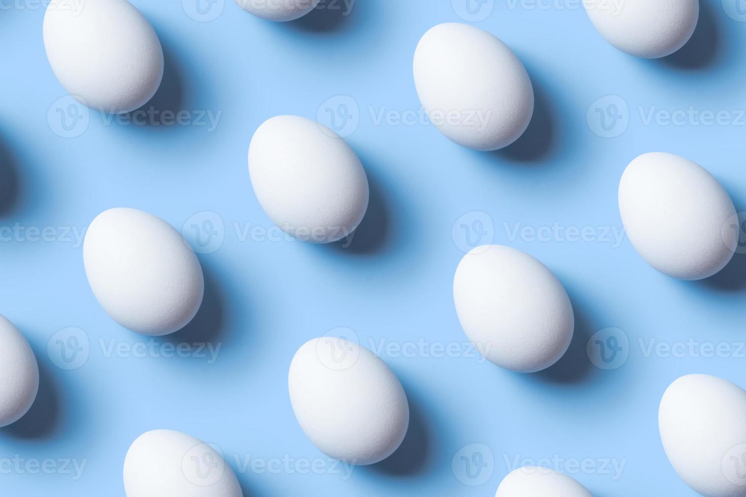 Creative composition with pattern from white eggs on blue background. Copy space photo