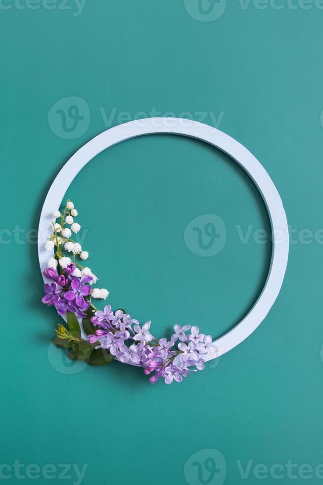 Spring composition. Lily of the valley and lilac flowers with round frame copy space. Summer, spring floral concept photo