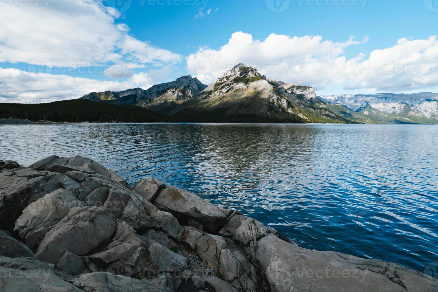 lago minnewanka en alberta, Canadá en un nublado día con maravilloso montañas y agua reflexiones foto