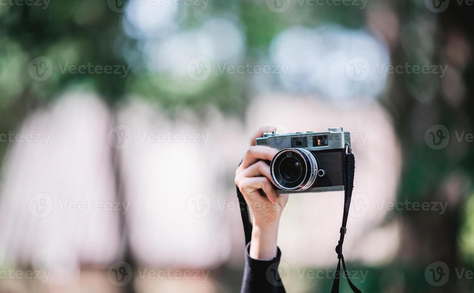 Hands of Female Professional photographer takes snapshots in forest photo