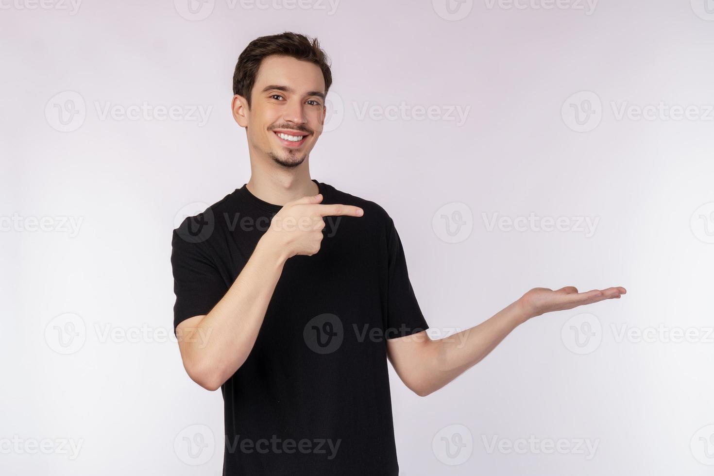 Portrait of happy smiling young man presenting and showing your text or product isolated on white background photo