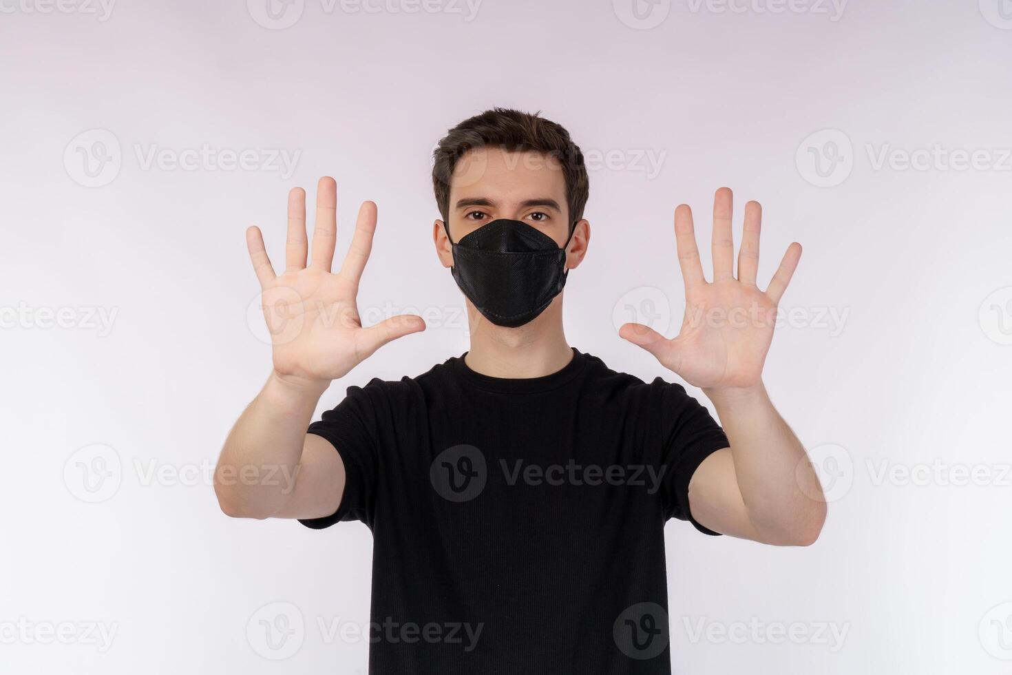 Portrait of young handsome man wearing medical mask doing stop sing with palm of the hand over white background photo