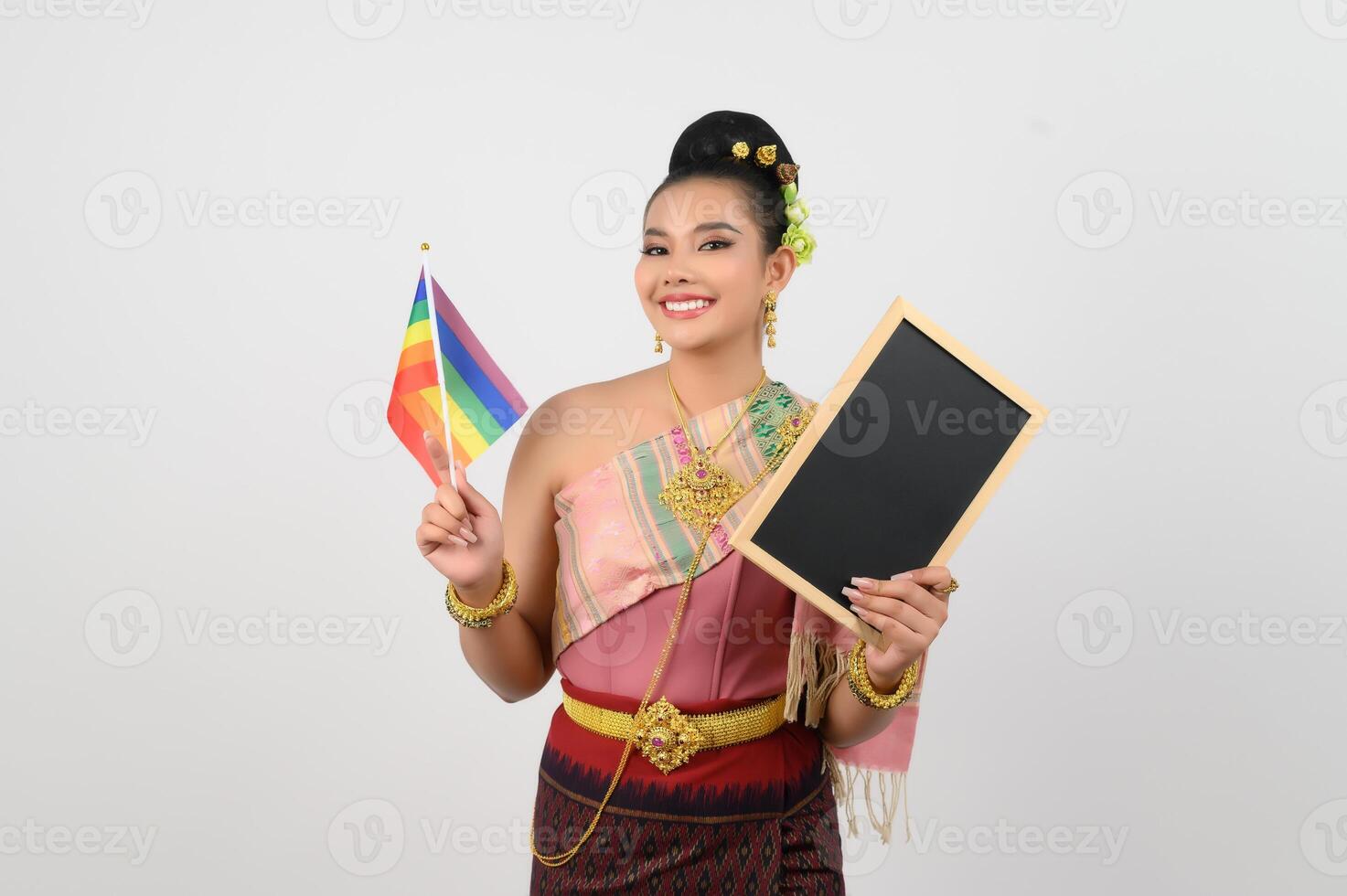 Young beautiful woman dress up in hai northeastern region holding rainbow flag and blackboard photo