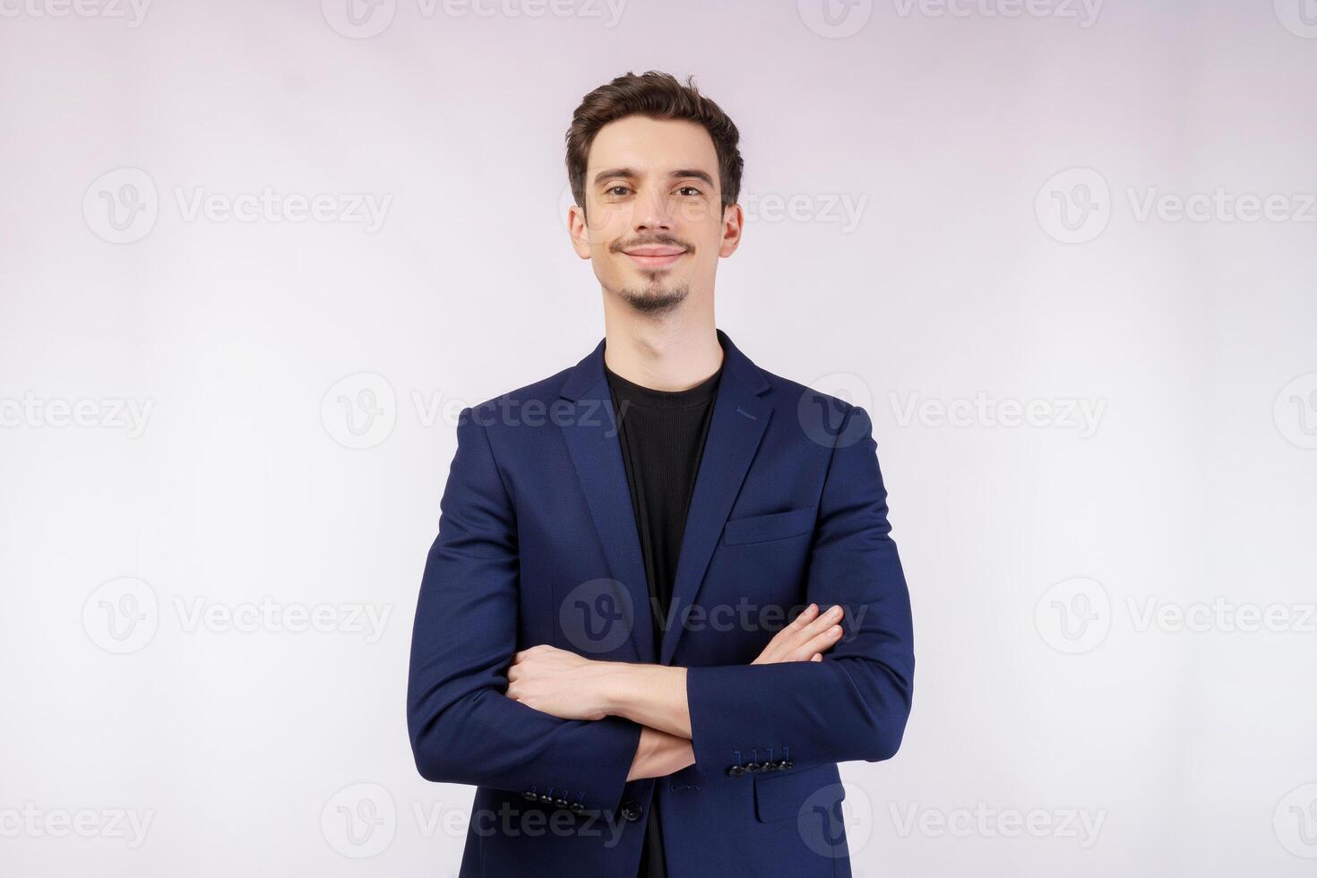 Portrait of young handsome businessman wearing suit standing with crossed arms with isolated on studio white background photo