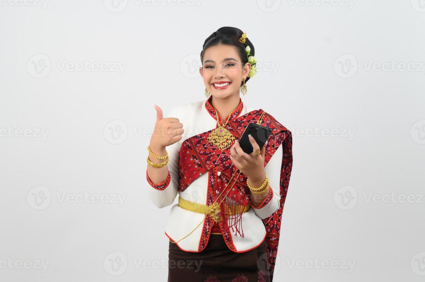 Young beautiful woman dress up in Thai northern region pose with smartphone photo