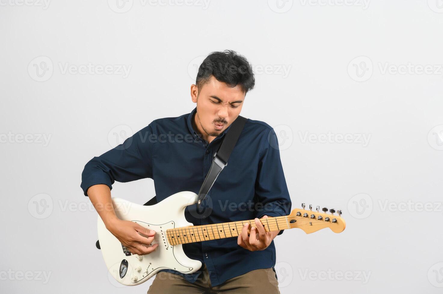 Portrait of Young Asian man in blue shirt with electronic guitar isolated on white background photo