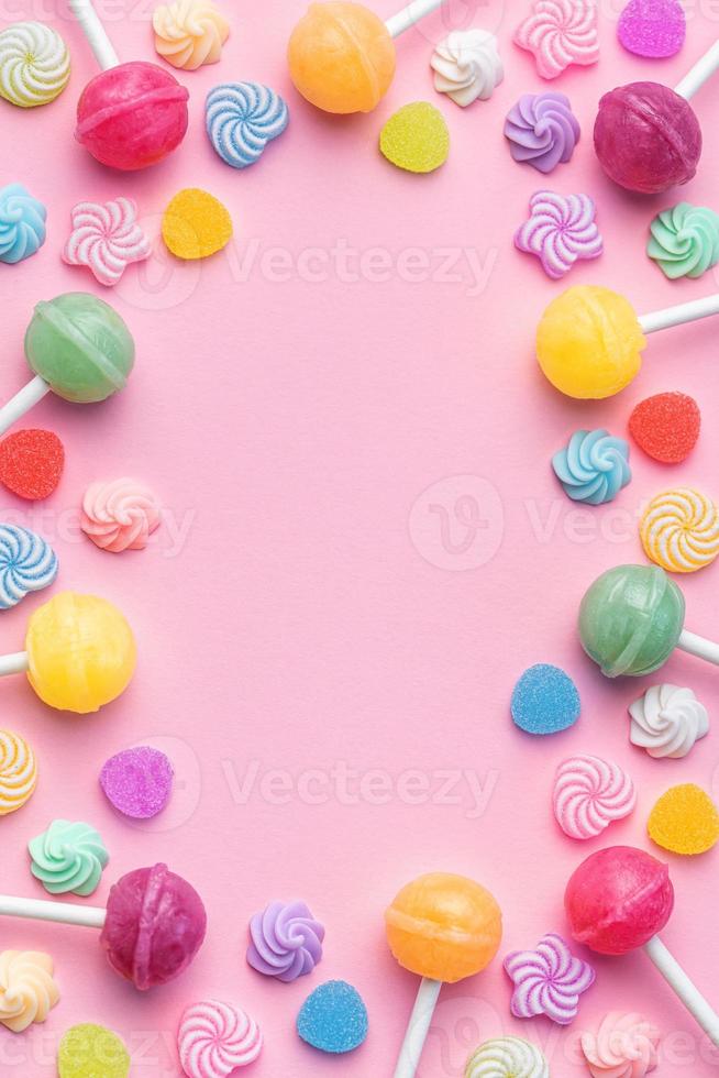 Sweet lollipops and candies on pink background photo