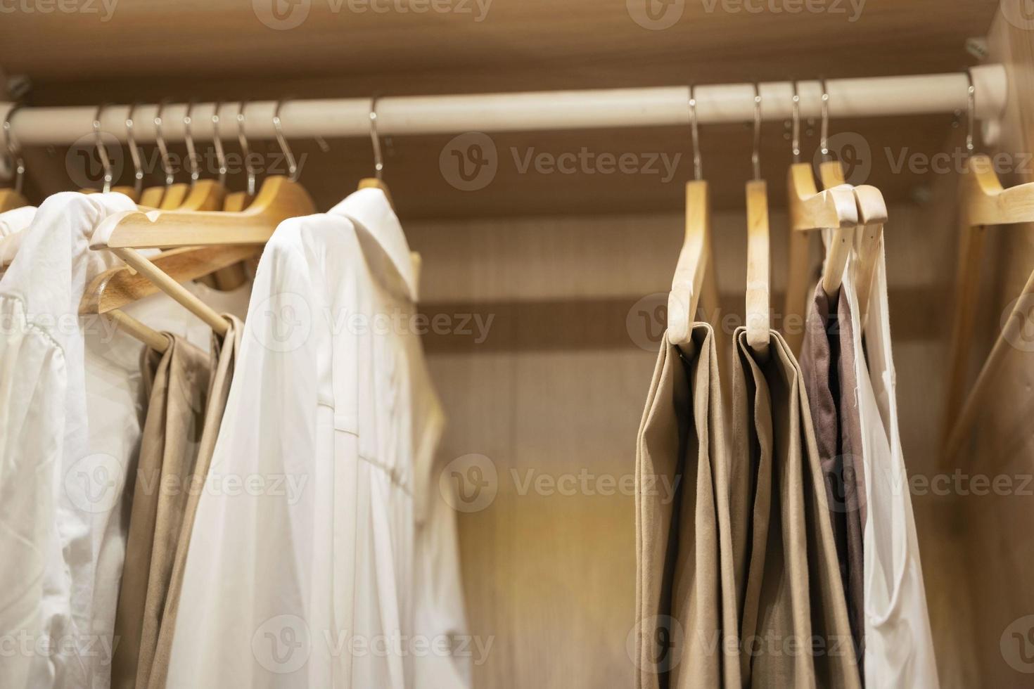 clothes, t-shirts, dresses hang on a hanger in the home closet photo