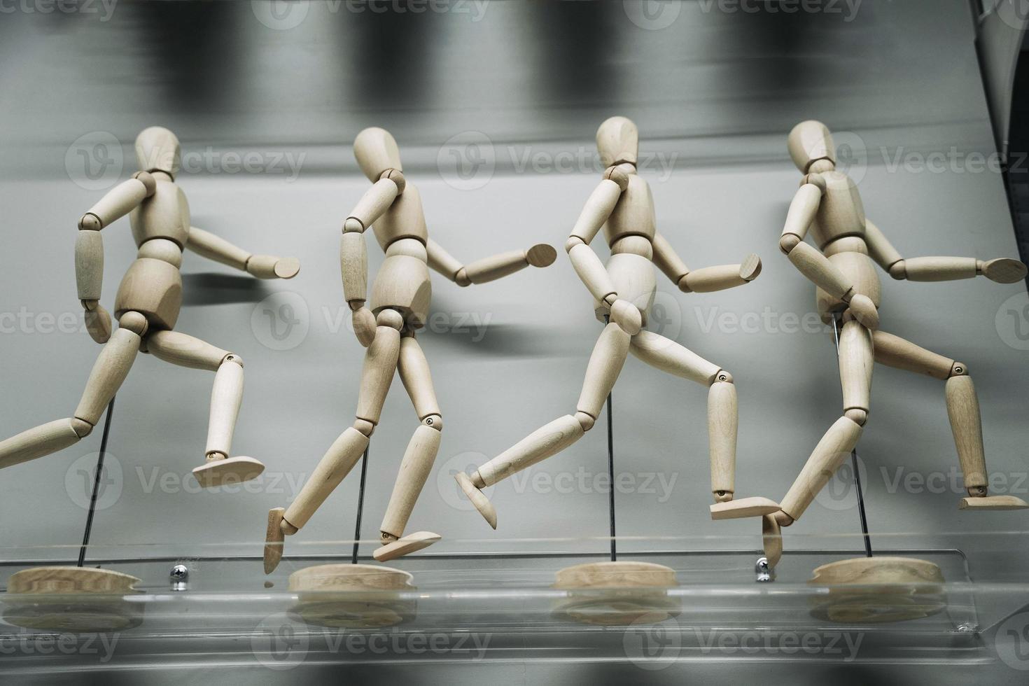 wooden figures of people running after each other photo