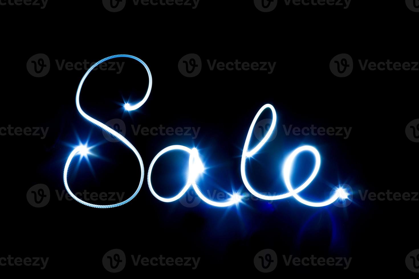 Glowing inscription SALE on a black photo