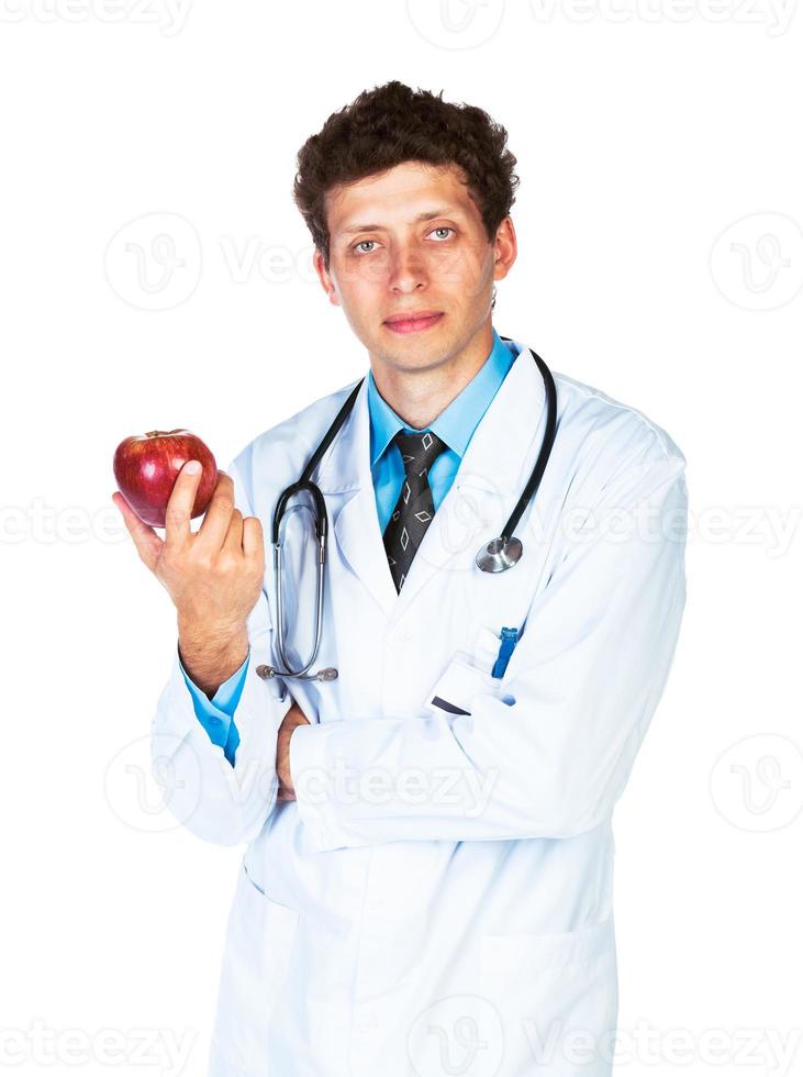 Portrait of a male doctor holding red apple on white photo