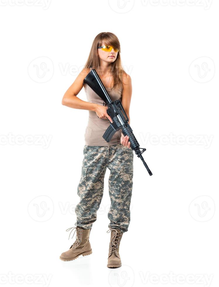 Soldier young beautiful girl dressed in a camouflage with a gun in his hand on white photo