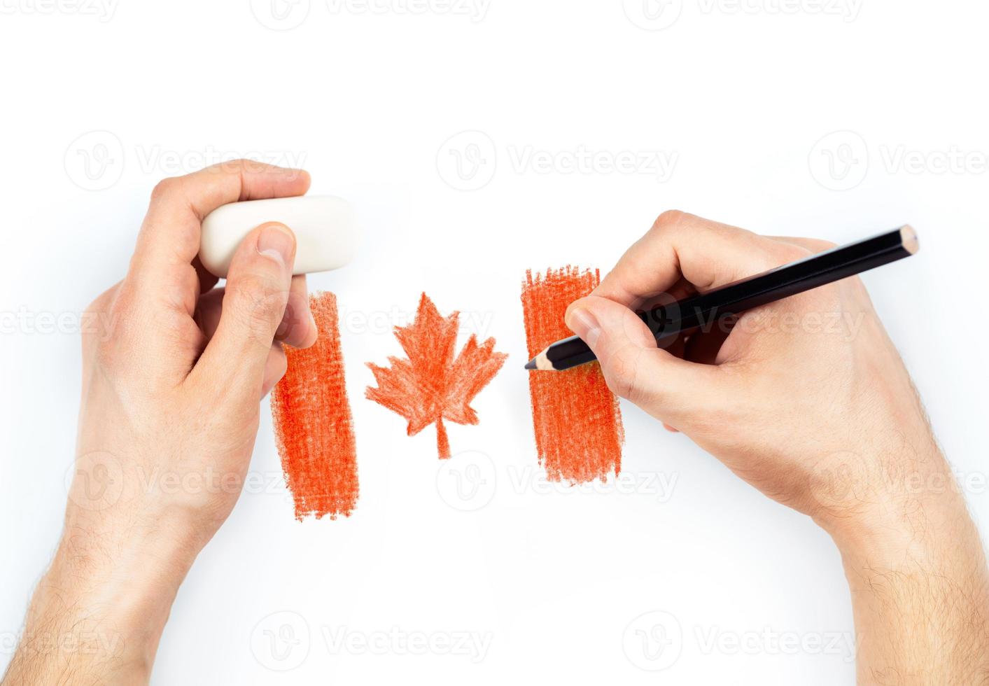 Man's hands with pencil draws flag of Canada on white photo