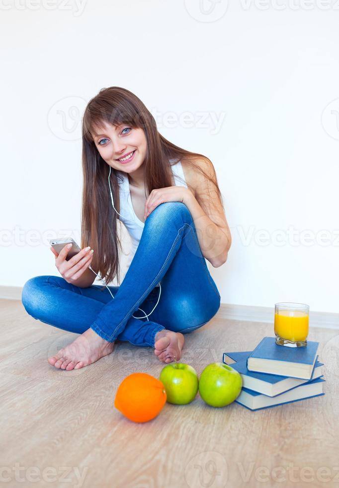 Portrait of a young woman with headphones and green apple listening music photo