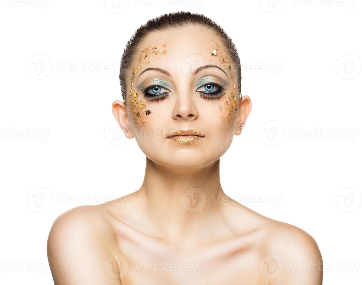 Glamorous portrait of young beautiful girl with big blue eyes, lush lashes and bright golden makeup photo