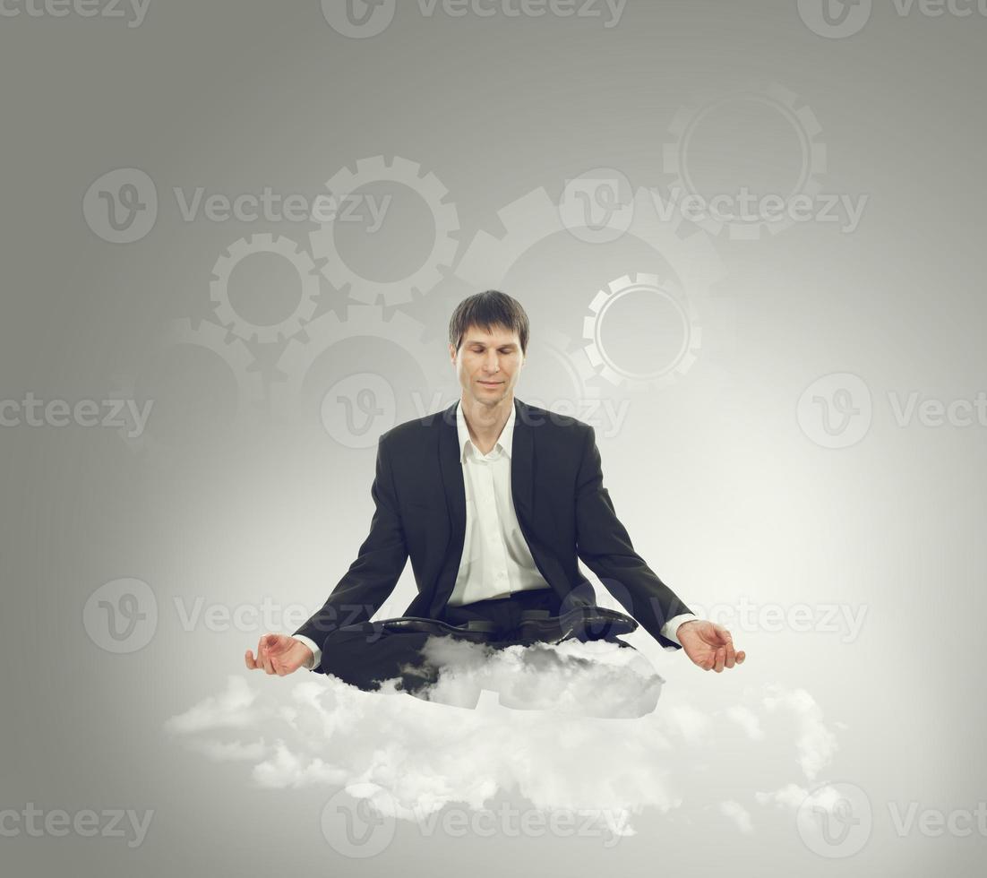 Businessman sitting in lotus position on a cloud photo