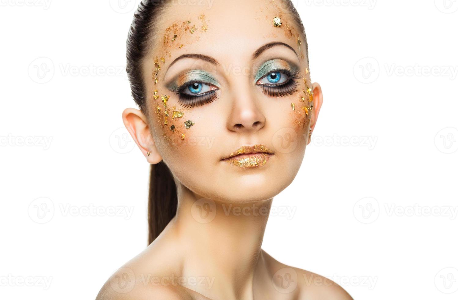 A beautiful young woman with golden face paint and glitter