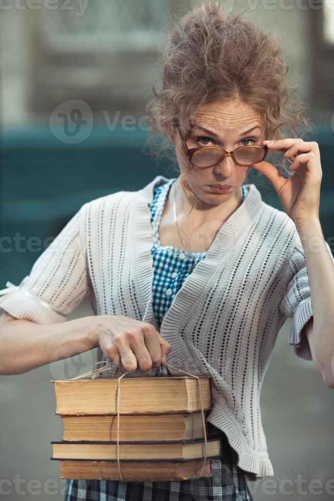 Funny girl student with books in glasses and a vintage dress photo