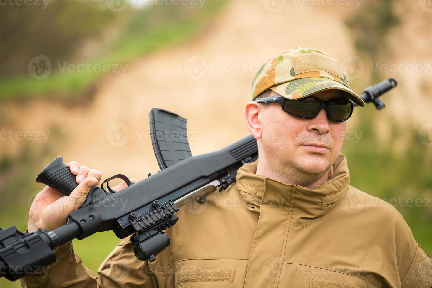 Man in camouflage with a shotgun photo