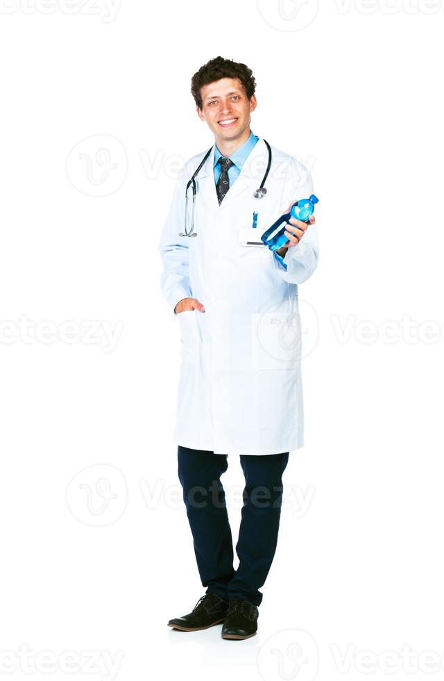 Portrait of a smiling male doctor holding bottle of water on white photo