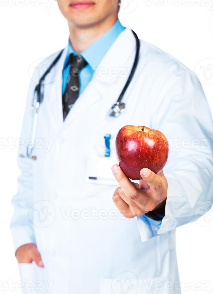 Doctor holding red apple on white close-up photo