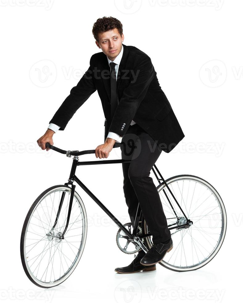 Attractive man in a classic suit with a bicycle on a white photo