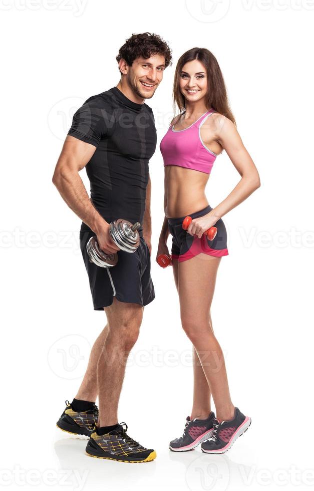 Athletic man and woman with dumbbells on the white photo