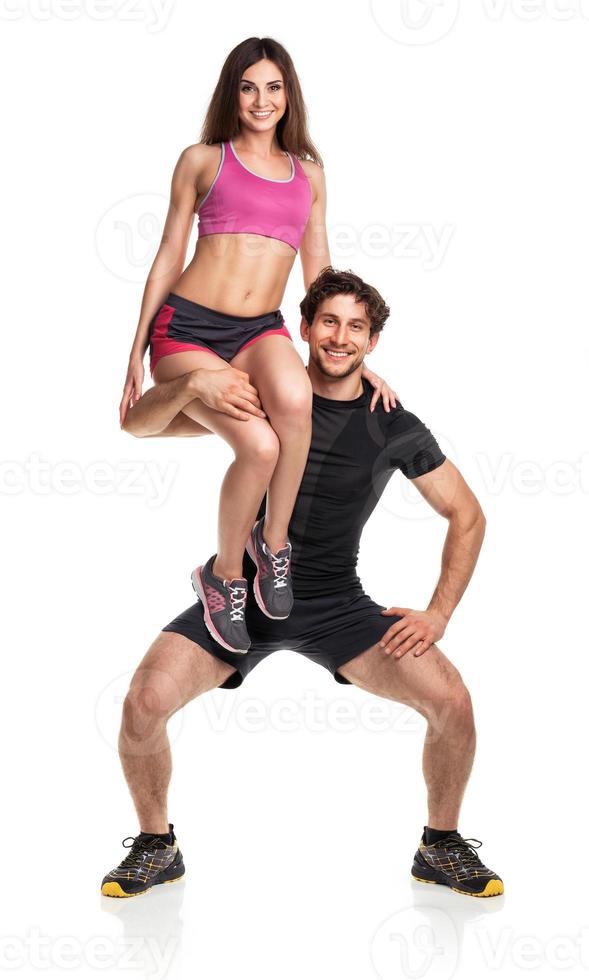 Sports guy holds on shoulder a girl on a white photo