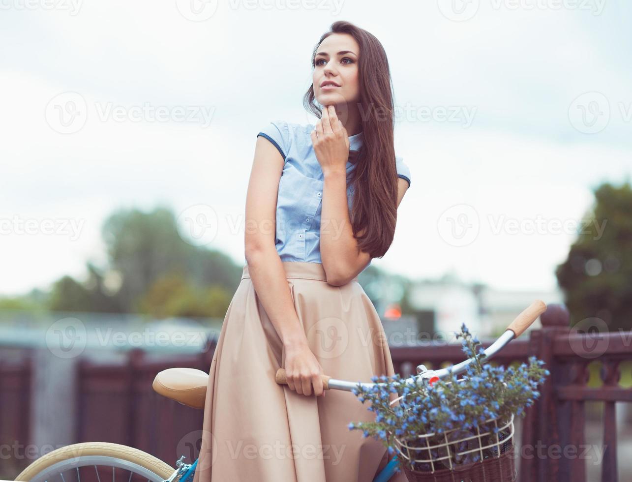 Beautiful, elegantly dressed woman with bicycle. Beauty, fashion and lifestyle photo