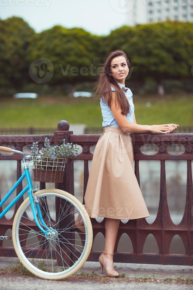 Young beautiful, elegantly dressed woman with bicycle, summer and lifestyle photo
