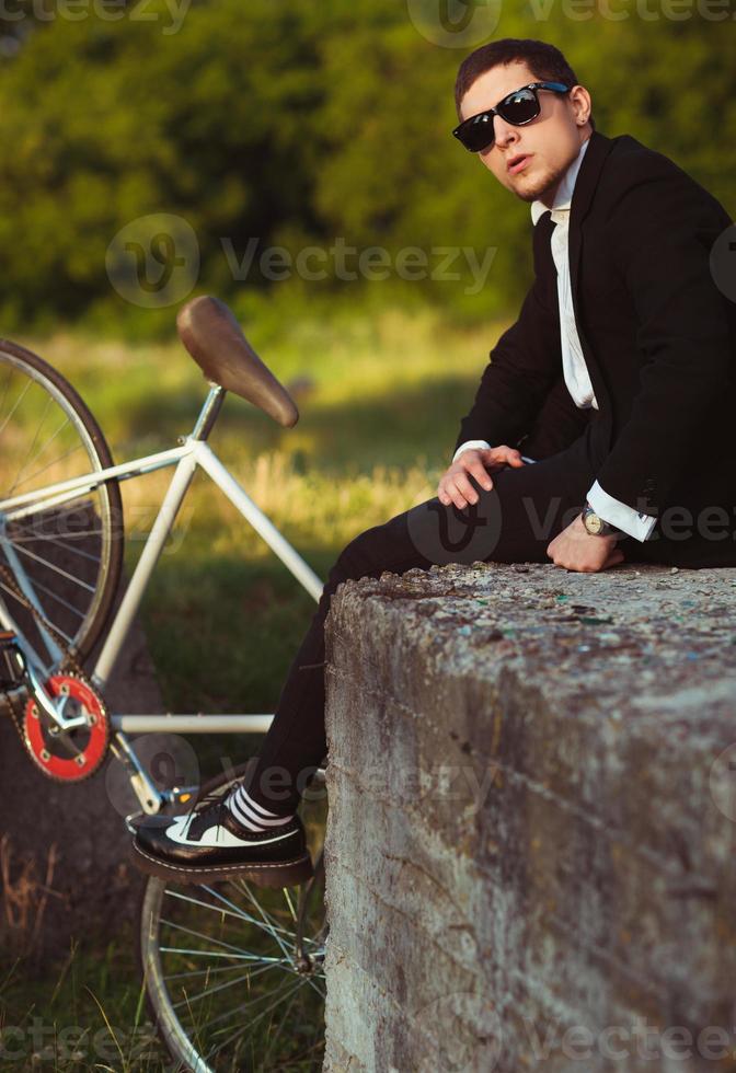 Young stylish guy with bicycle outdoors photo